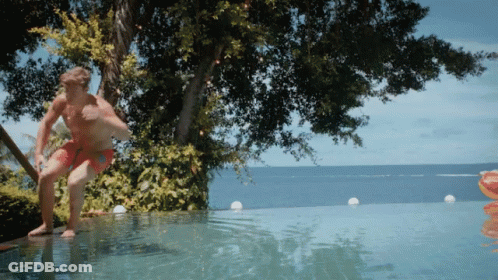 A Man Is Jumping Into An Infinity Pool GIF