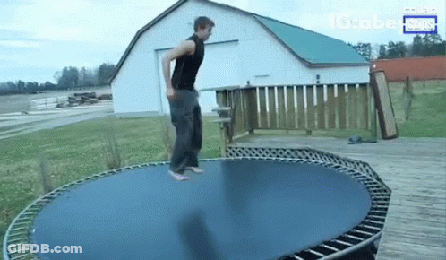 A Man Is Jumping On A Trampoline In Front Of A Barn And A Sign That Says Globe News GIF