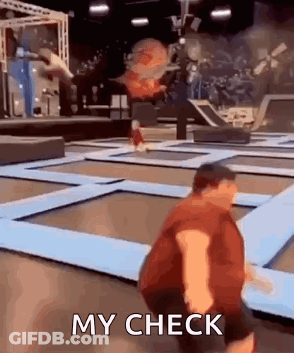 A Man Is Jumping On A Trampoline With The Words `` My Check '' Written Below Him . GIF