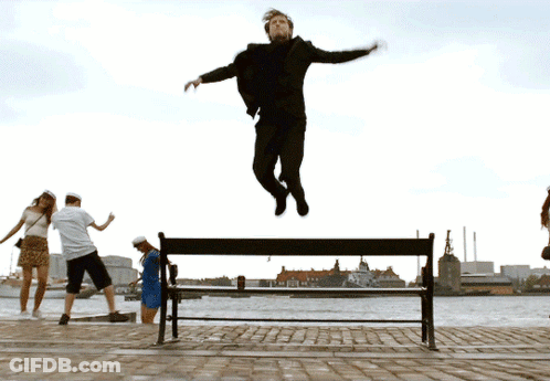 A Man Is Jumping Over A Bench In The Air GIF