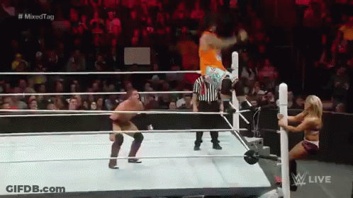 A Man Is Jumping Over A Woman In A Wrestling Ring During A Mixed Tag Match . GIF