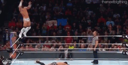 A Man Is Jumping Over Another Man In A Wrestling Ring . GIF
