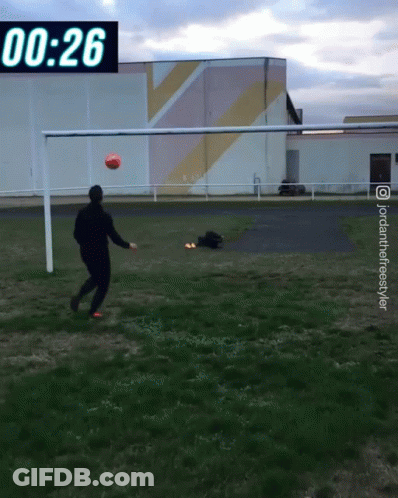 A Man Is Kicking A Soccer Ball In Front Of A Scoreboard That Says 0:26 GIF