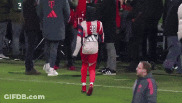 A Man Is Kicking A Soccer Ball On A Soccer Field With A Crowd Watching . GIF