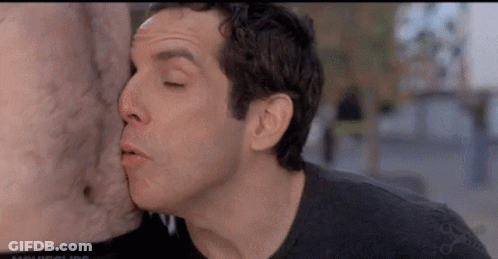 A Man Is Kissing A Statue Of A Man 'S Chest . GIF