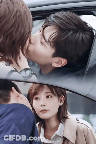 A Man Is Kissing A Woman On The Cheek In A Car While A Woman Looks On GIF