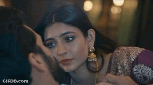 A Man Is Kissing A Woman On The Cheek In A Close Up . GIF