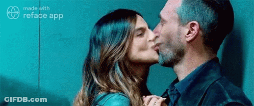 A Man Is Kissing A Woman On The Cheek . GIF