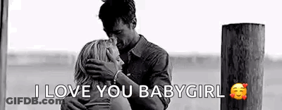 A Man Is Kissing A Woman On The Forehead While Hugging Her . GIF