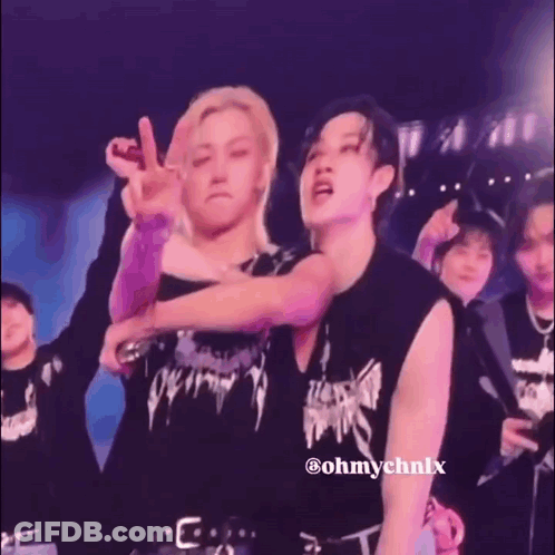 A Man Is Kissing Another Man On The Cheek On Stage . GIF