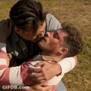 A Man Is Kissing Another Man On The Forehead While They Are Hugging Each Other . GIF