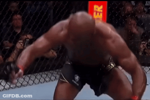 A Man Is Kneeling Down In A Boxing Ring With A Red Sign In The Background That Says Gr GIF