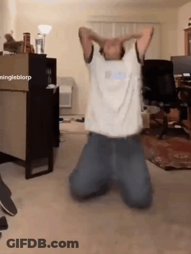 A Man Is Kneeling Down In A Living Room With His Arms Outstretched GIF