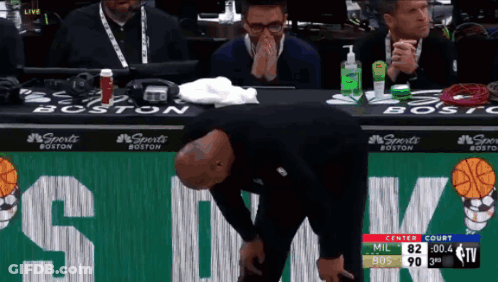 A Man Is Kneeling Down In Front Of A Sign That Says Boston GIF