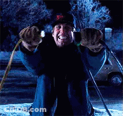 A Man Is Kneeling Down In The Snow Holding A Pair Of Skis GIF