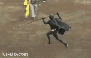 A Man Is Kneeling Down Next To A Bull In A Ring . GIF