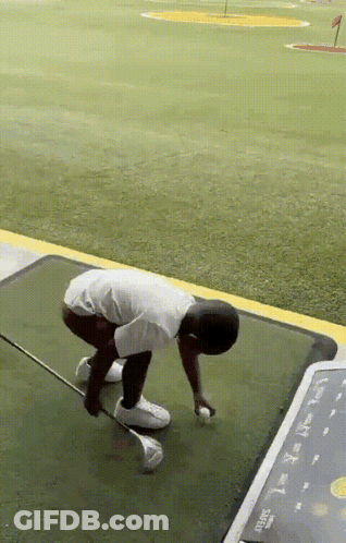 A Man Is Kneeling Down On A Golf Course With A Golf Club In His Hand GIF
