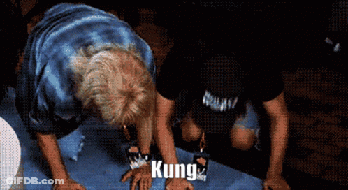 A Man Is Kneeling Down With The Word Kung Written On His Hands GIF