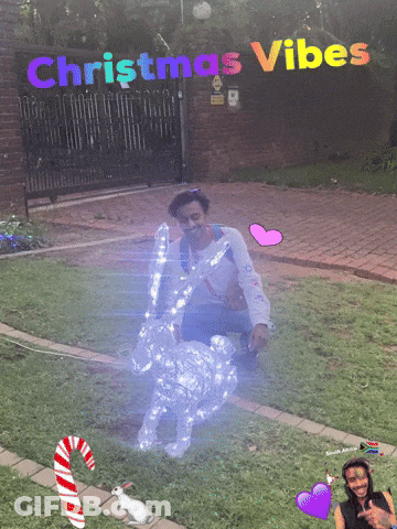 A Man Is Kneeling In Front Of A Christmas Decoration GIF