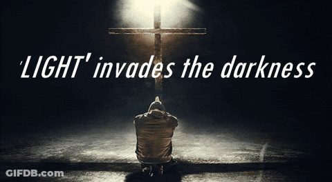 A Man Is Kneeling In Front Of A Cross With The Words Light Invades The Darkness Above Him GIF