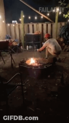A Man Is Kneeling In Front Of A Fire Pit With Failarmy Written Above Him GIF