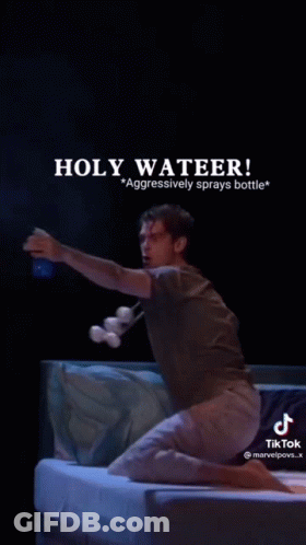 A Man Is Kneeling On A Bed Holding A Bottle Of Water And A Bottle Of Marshmallows . GIF