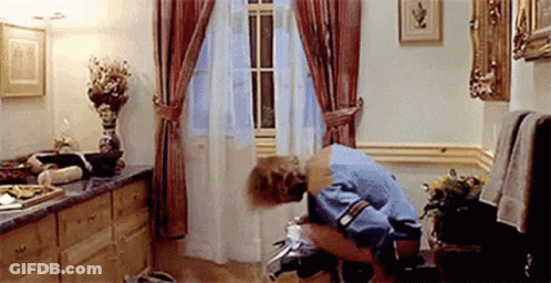 A Man Is Kneeling On A Toilet In A Bathroom . GIF