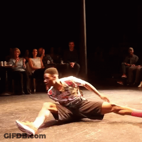 A Man Is Kneeling On The Floor In Front Of A Crowd GIF
