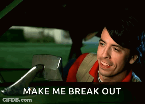 A Man Is Laughing In A Car With The Words Make Me Break Out Above Him GIF