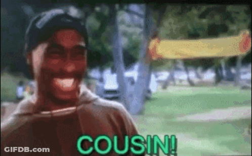 A Man Is Laughing In A Park With The Word Cousin Written On The Screen . GIF