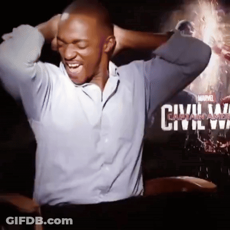 A Man Is Laughing In Front Of A Movie Poster For Civil War GIF