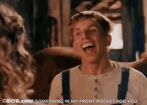 A Man Is Laughing While Talking To A Woman In A Room . GIF
