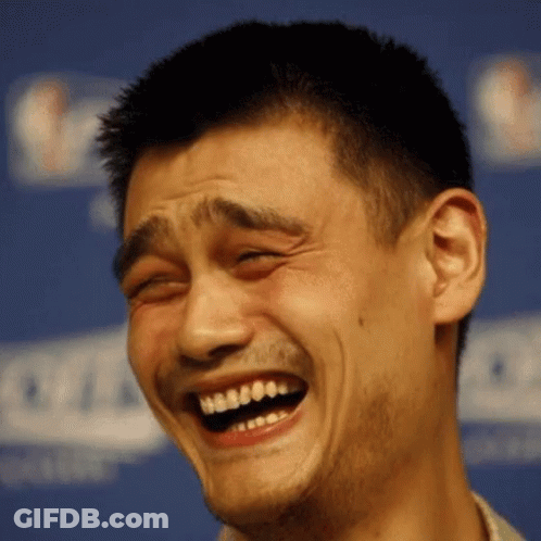 A Man Is Laughing With His Eyes Closed In Front Of A NBA Sign GIF