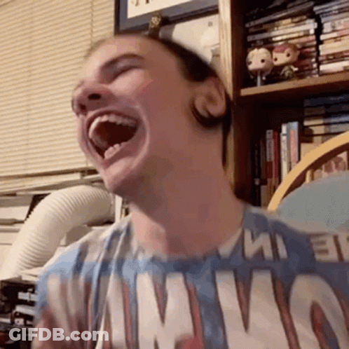 A Man Is Laughing With His Mouth Open And Wearing A T-Shirt That Says Nirvana . GIF