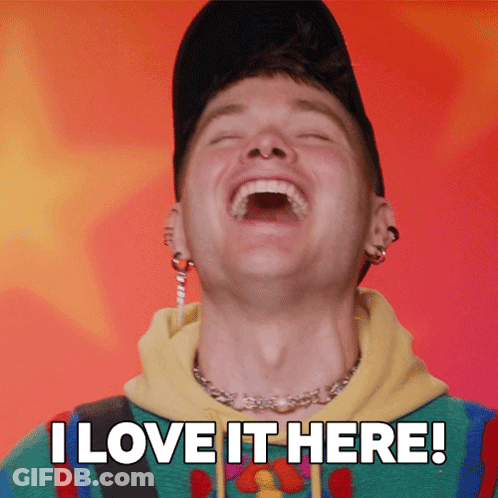 A Man Is Laughing With The Words " I Love It Here " Behind Him GIF