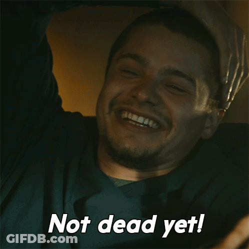 A Man Is Laughing With The Words Not Dead Yet Written Below Him GIF
