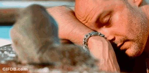 A Man Is Laying Down With His Head On His Wrist . GIF