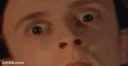 A Man Is Laying In A Bed With His Eyes Closed And A Polka Dot Blanket . GIF