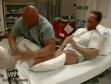 A Man Is Laying In A Hospital Bed Getting A Massage From A Nurse . GIF