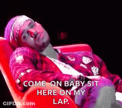 A Man Is Laying In A Red Chair With The Words `` Come On Baby Sit Here On My Lap '' Written On It . GIF