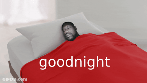 A Man Is Laying In Bed With A Red Blanket That Says Goodnight On It GIF
