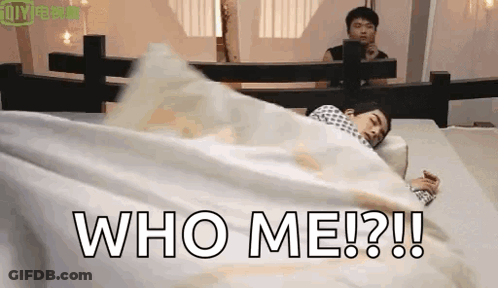 A Man Is Laying In Bed With A White Blanket And The Words `` Who Me ? '' Written On It . GIF