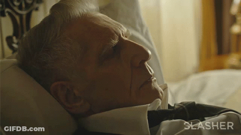 A Man Is Laying In Bed With The Word Slasher On The Bottom Right GIF