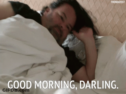 A Man Is Laying In Bed With The Words " Good Morning Darling " On The Bottom GIF
