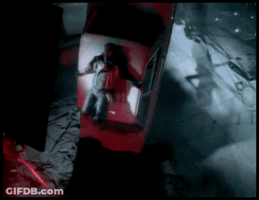 A Man Is Laying In The Back Of A Red Car In A Dark Room GIF