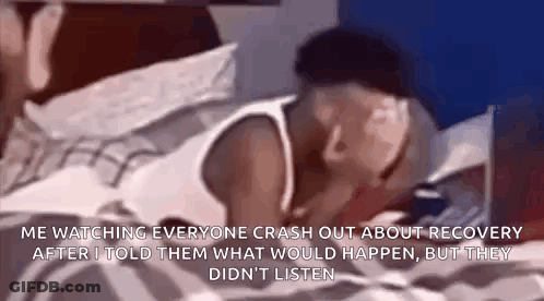 A Man Is Laying On A Bed And Talking On A Cell Phone While Watching Everyone Crash Out About Recovery . GIF