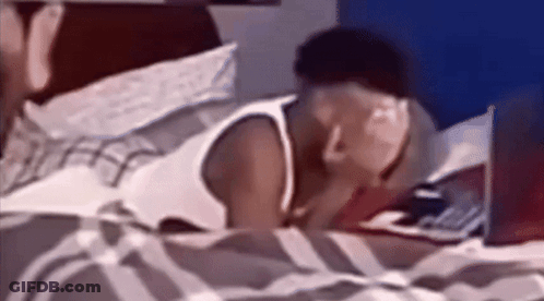 A Man Is Laying On A Bed With A Laptop GIF