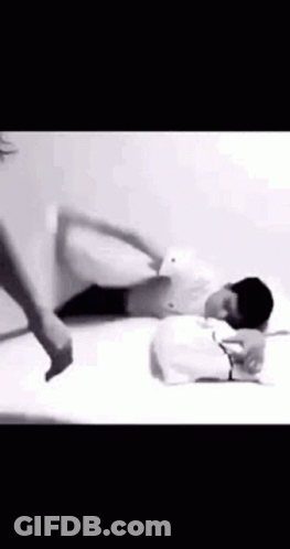A Man Is Laying On A Bed With A Pillow On His Head . GIF