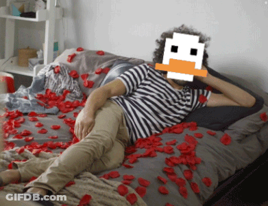 A Man Is Laying On A Bed With A Pixelated Duck Face On His Face GIF
