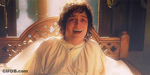 A Man Is Laying On A Bed With His Mouth Open And Looking At The Camera With A Surprised Look On His Face . GIF